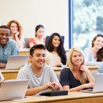 Image of students with laptops in a lecture classroom