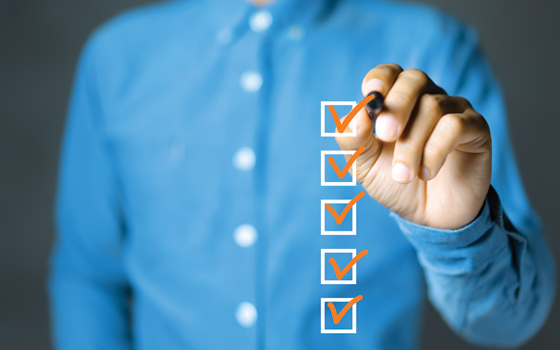 Businessman checking mark on the check boxes with marker orange