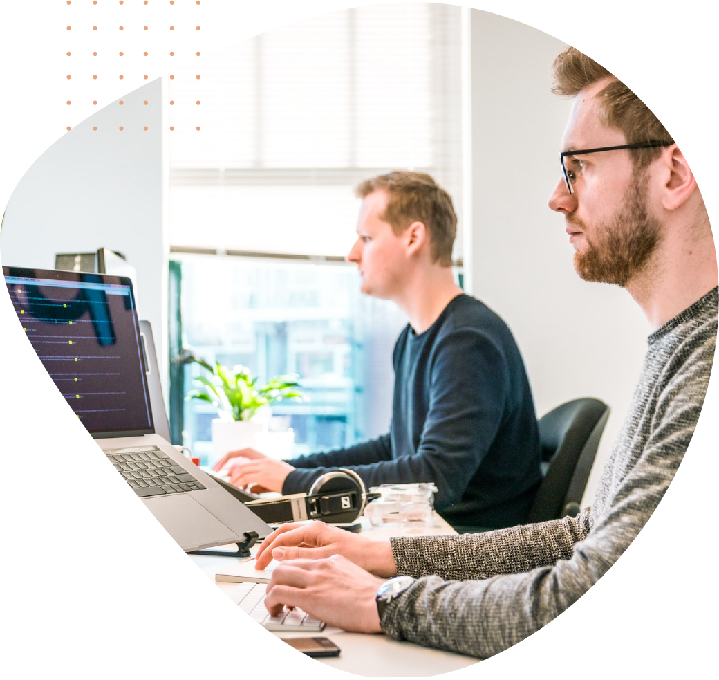 Two people sitting at desks on computers